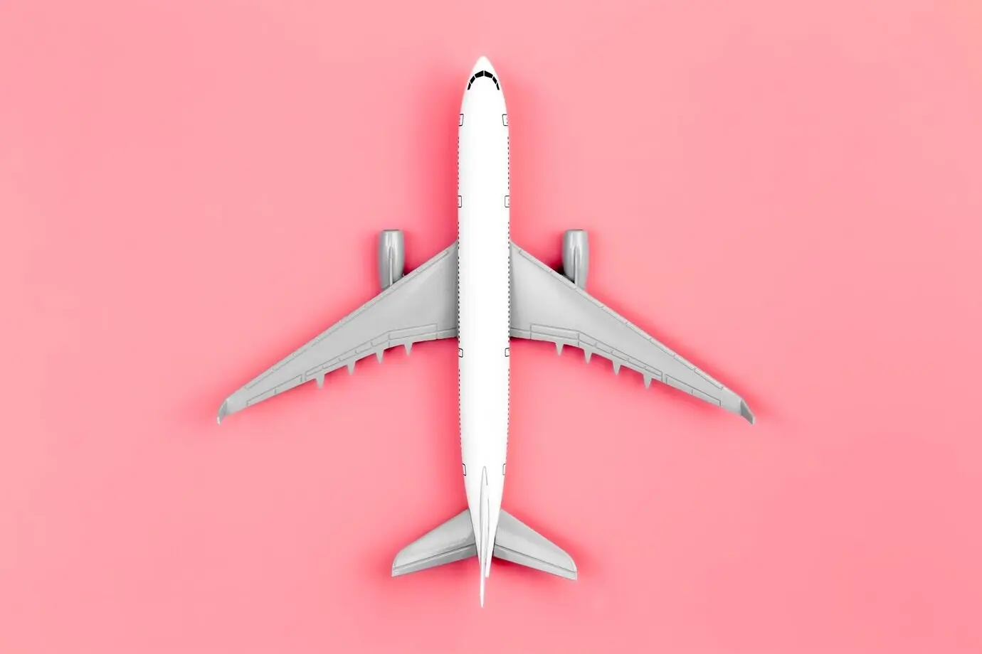 Flugzeug auf pinkem Hintergrund, Flatlay-Reisekonzept.